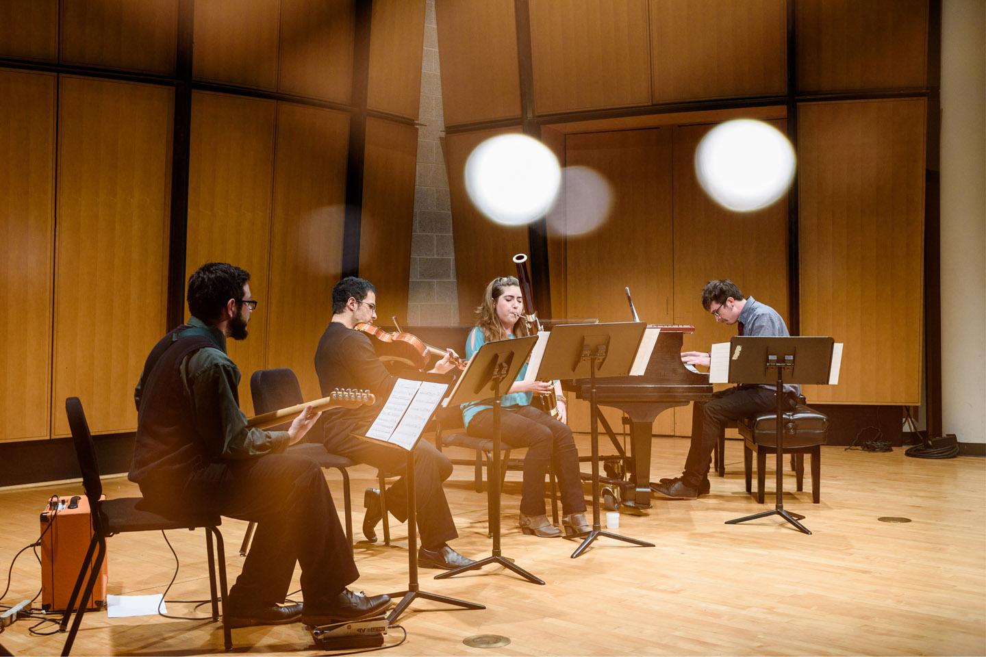 Chamber music group performing with piano, bassoon, violin, and guitar