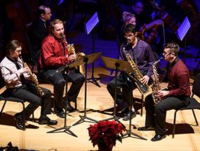 Saxophone quartet performing on stage in blue light