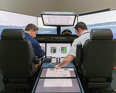 Two MSU Denver students operating a flight simulator on Auraria Campus.